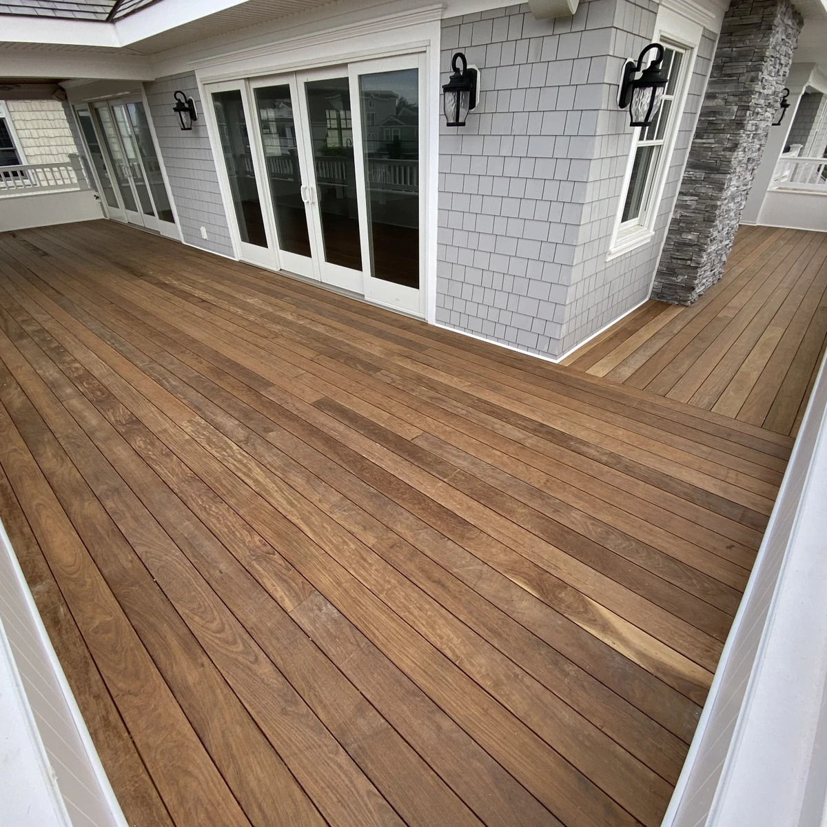 Wood-tone deck with white railings and detailed border boards